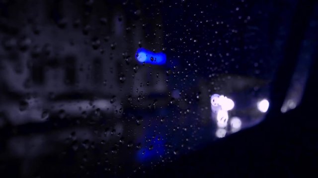 Wet glass car night interior. Night road in rain blue colour
