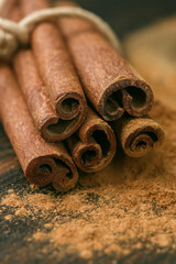 Cinnamon sticks and powder on rustic wooden Board closeup. Spices. Seasonings. Selective focus