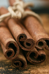 Cinnamon sticks and powder on rustic wooden Board closeup. Spices. Seasonings. Selective focus