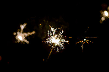 Fototapeta premium Christmas sparklers shining in the dark.