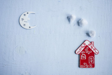 Flat lay composition of the  red house toy with chimney and white wooden moon