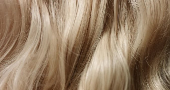 Close up video of woman's long wavy blond hair