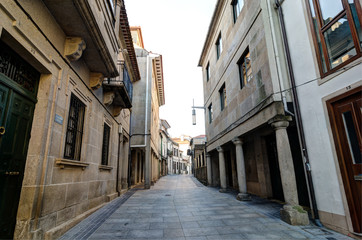 Fototapeta na wymiar Street corridor in Pontevedra historic center. Columns and masonry walls