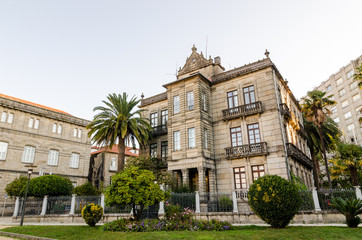 Fototapeta na wymiar Historical masonry building in Vincenti gardens in Pontevedra (Spain). Palms and plants in the entrance
