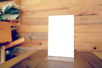 Mock up Menu frame standing on wood table in Bar restaurant cafe. space for text.