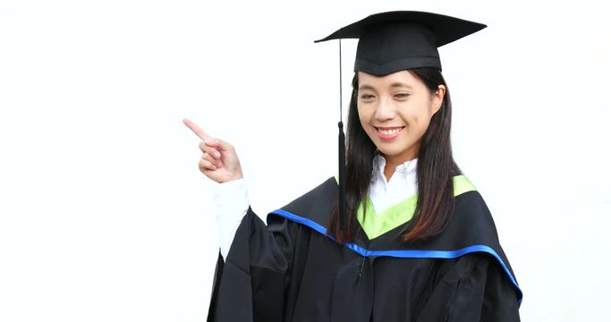 Woman wearing graduation gown and showing finger point aside