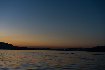 sunset on lake lucerne with mountains viewed from boat clear sky