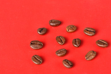 Obraz na płótnie Canvas Texture of grains of caffeine.Place for text.Roasted coffee beans.Advertising for coffee.Coffee beans on a red background.