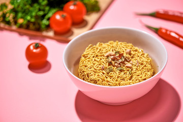 A Bowl of instant noodles on pink background
