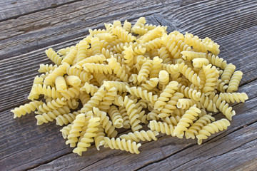 Fusilli pasta on wooden background