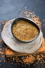 Bowl of indian red lentils soup or masoor dal served with chapati flatbread, studio shot, selective focus