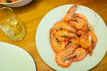A dinner of many cooked orange king shrimps in carapaces