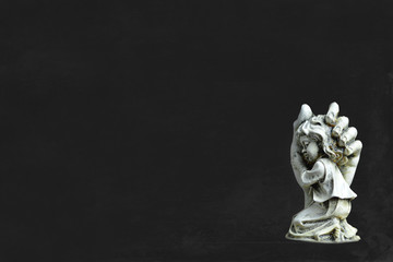 Condolence card. Angel on dark background with copy space.