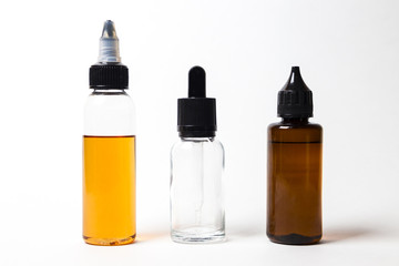 e- liquid, e-juice in the bottles isolated on the white background with copyspace