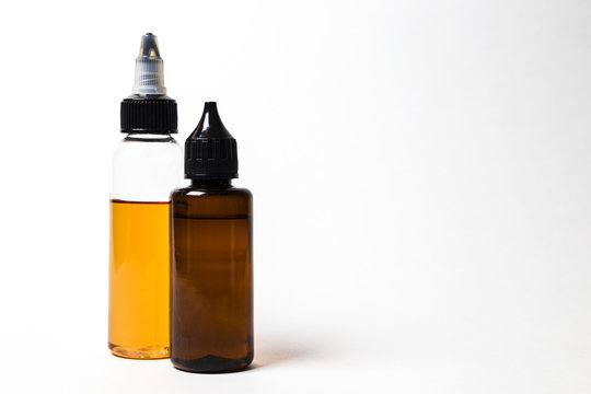 e- liquid, e-juice in the bottles isolated on the white background with copyspace