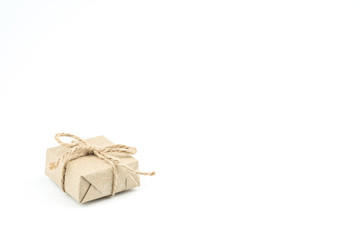 Vintage brown craft paper gift box tied with brown rope bow ribbon isolated on white background for Christmas, New Year and Valentine Day present.