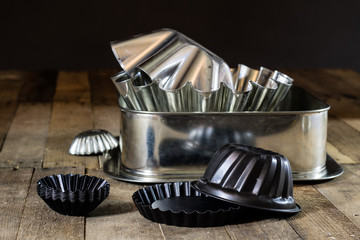 Old baking molds on an old kitchen table. Baking accessories in the kitchen.