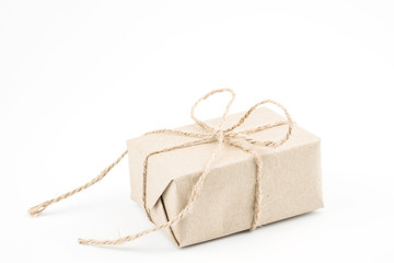 Vintage brown craft paper gift box tied with brown rope bow ribbon isolated on white background for Christmas, New Year and Valentine Day present.