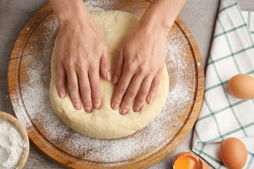 Female chef with dough on kitchen table