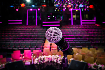 close up microphone against blur colorful light in music studio