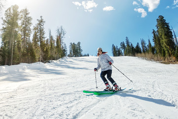 Young girl on alpine skiing on a snowy track against the sky