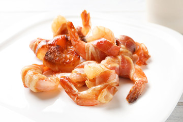 Shrimps wrapped in bacon on plate, closeup