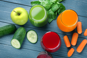 Glasses with various fresh juices and ingredients on table