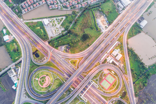 Aerial view of urbal highway intersection road with green exercise background