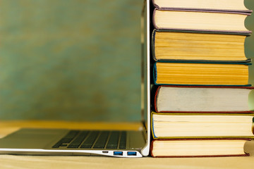on the table are books and an open laptop.