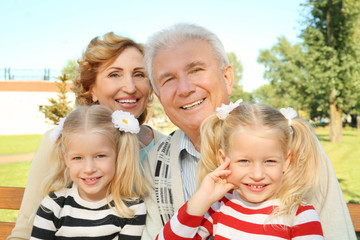 Fototapeta premium Elderly couple with granddaughters in park