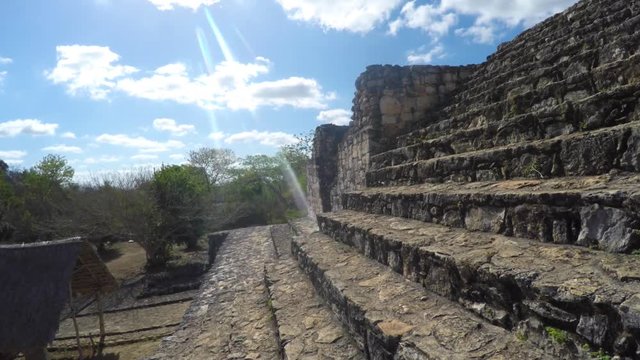 A gimbal shot of woman sitting in mayan ruins in ek balam