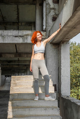 Fitness girl on the old stairs in an abandoned factory