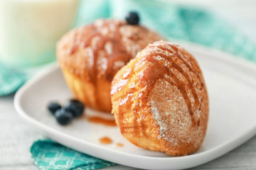 Delicious muffins with caramel topping on plate