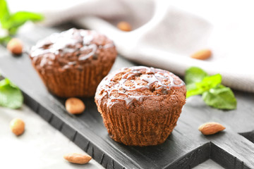 Delicious chocolate muffins with caramel topping on wooden board