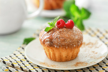 Plate with delicious muffin and caramel on table