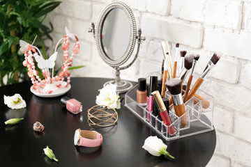 Obraz na płótnie Canvas Set of decorative cosmetics and beauty accessories on dressing table indoors