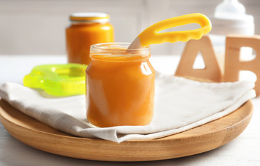 Jar with healthy baby food on table