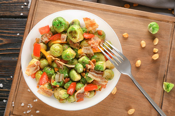 Bowl with brussel sprout salad on wooden board