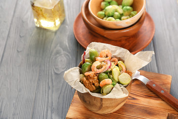 Wooden bowl with brussel sprout salad on table