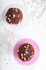 Tasty muffins with caramel and chocolate toppings on stands