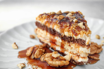 Plate with piece of delicious caramel cake on table