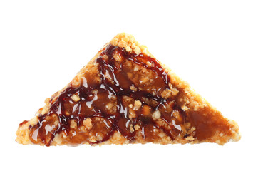 Piece of delicious cake with caramel sauce on white background