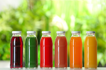 Bottles with fresh juices on table outdoors