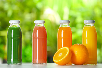 Bottles with fresh juices on table outdoors