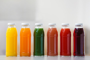 Bottles with fresh juices on table indoors