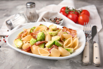 Plate of pasta with Brussels sprouts and bacon on table