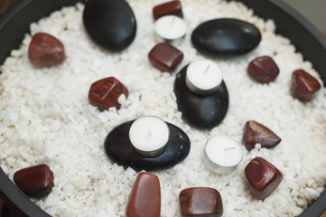 SPA concept aroma therapy salt, black and brown rock and candle in the clay pot.
