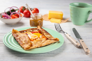Tasty thin buckwheat pancake with egg on plate