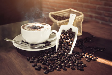 coffee cup and coffee beans on wooden table.