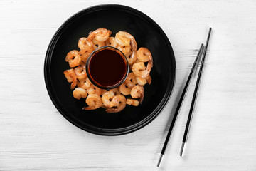 Plate with fresh tasty shrimp basket and sauce on table